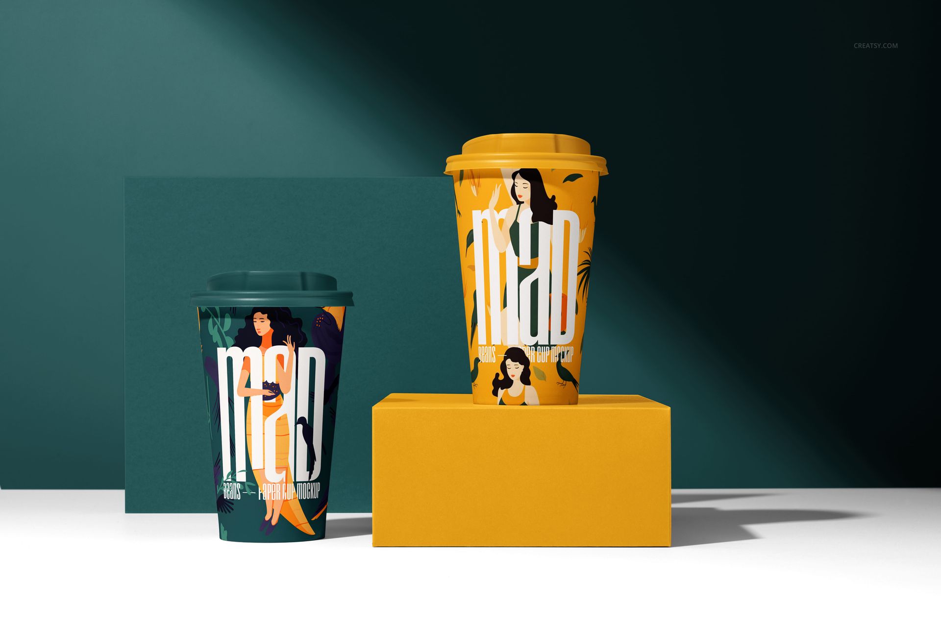 PSD mockup featuring two paper cups with vibrant graphics and large lettering, displayed on geometric props.