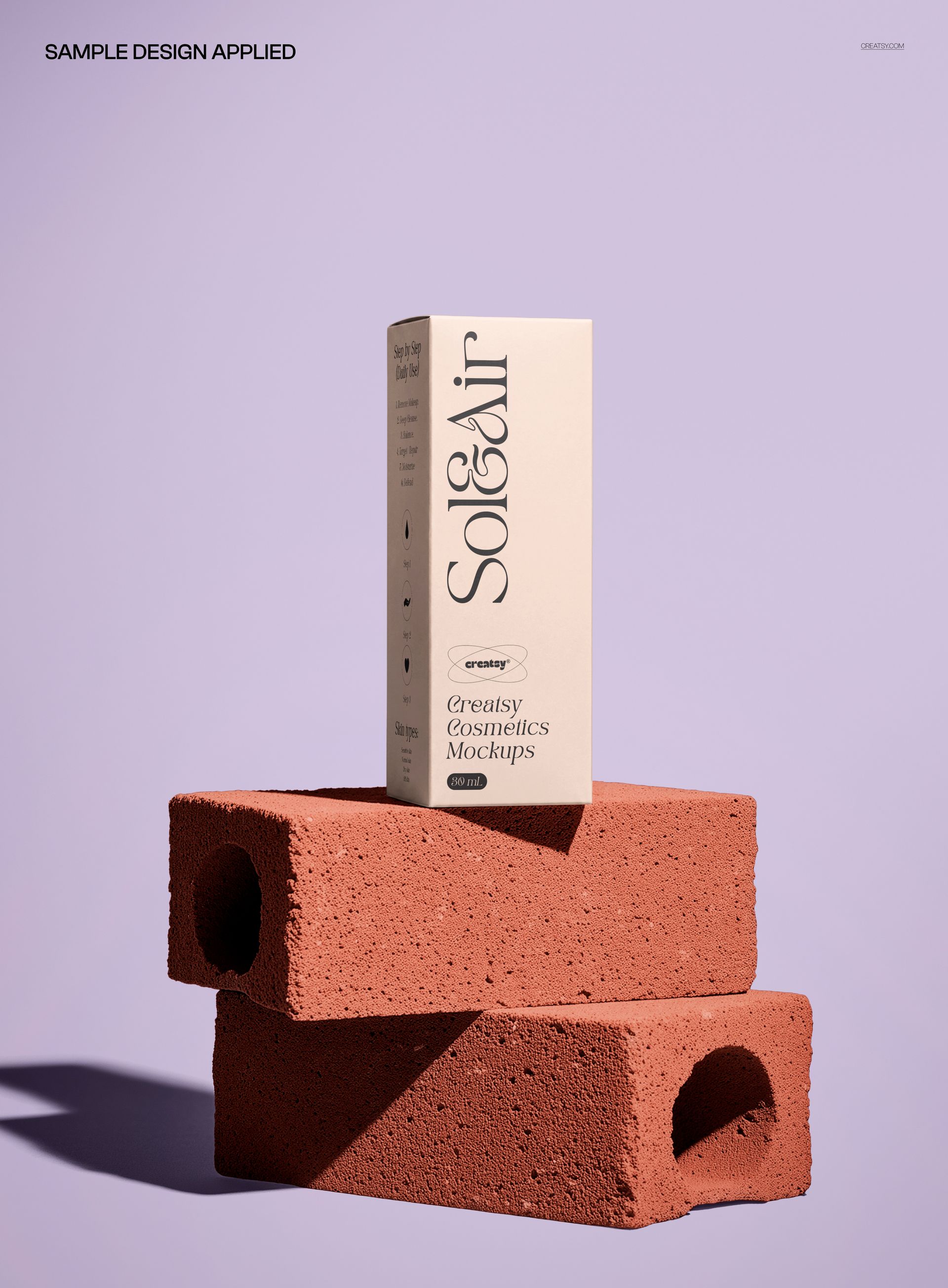 Front view of a skincare packaging box mockup placed atop two textured bricks, set on a pastel purple surface.