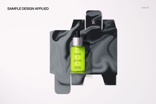 Green dropper bottle positioned on a flat unfolded carton mockup with abstract dark swirls, seen from above.