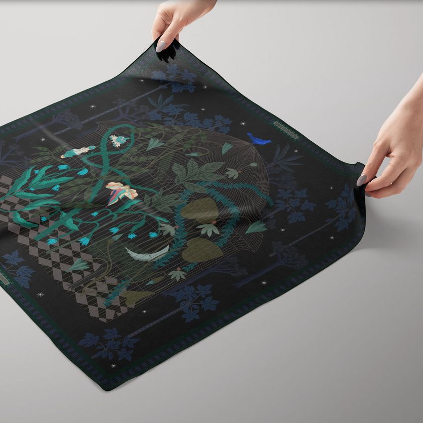 Square silk scarf mockup featuring hands holding the corners of a dark scarf with a botanical and geometric pattern on a light surface.