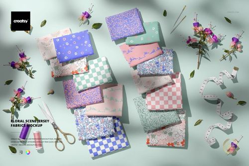 PSD mockup showing multiple folded jersey fabrics in various patterns, set on a pale background with tape measure and blooms.