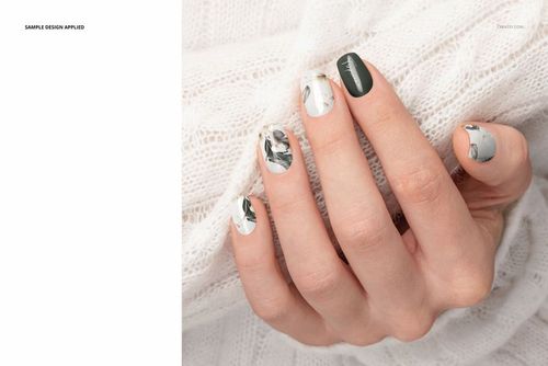 Squoval nails mockup with alternating solid green and abstract marble designs, shown on a hand in a cozy sweater.