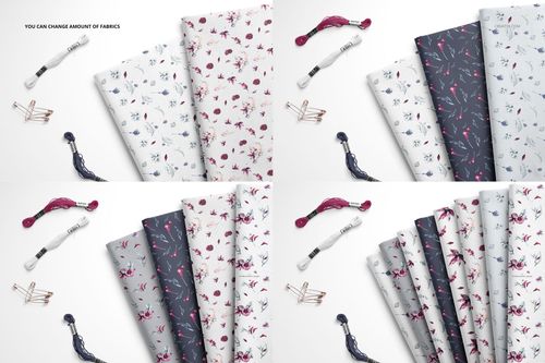 Folded fabrics in various floral and botanical patterns, shown from a top view with embroidery floss and safety pins nearby.