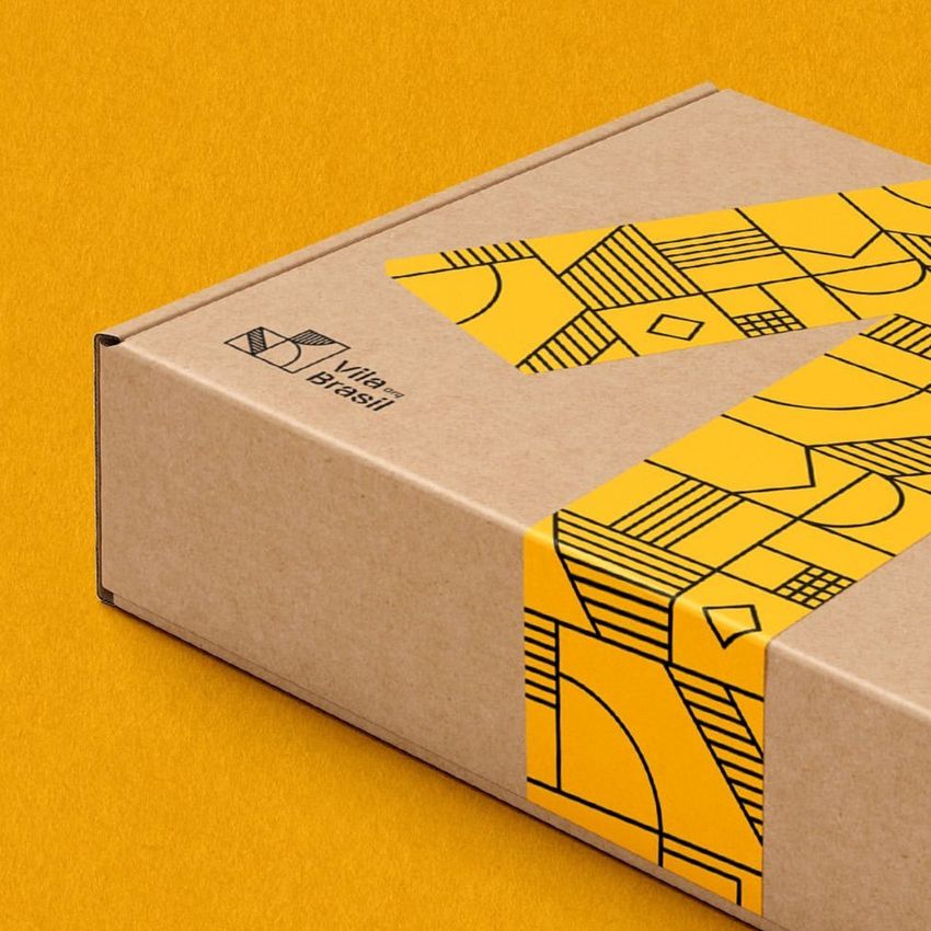 Mailing box mockup featuring a kraft cardboard box with geometric yellow tape and black printed text on a yellow background.