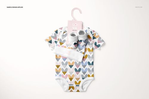 Front view of a baby onesie mockup with pastel heart print, accompanied by booties and hat, set on a white surface.