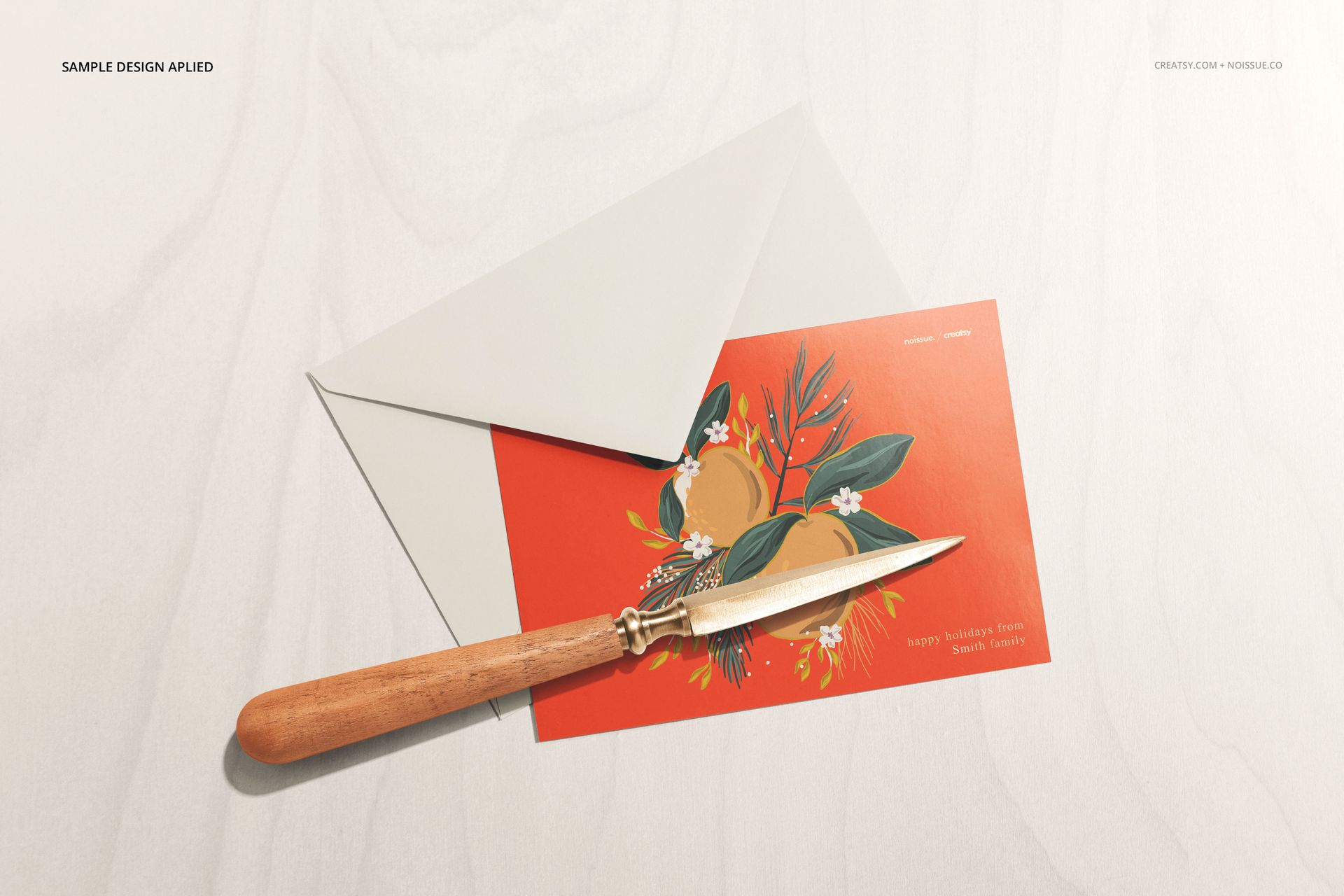 Stationery mockup featuring a red card with floral illustration, paired with a light gray envelope on a pale surface.