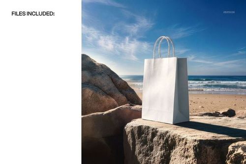 Paper shopping bag mockup displayed on a rocky surface at the beach, with ocean and clear sky in the background.