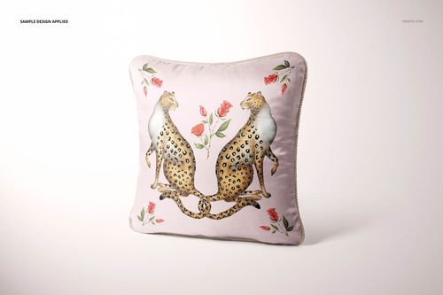 Silk pillow mockup with braided edge, decorated with two leopards and red roses, displayed on a plain backdrop.