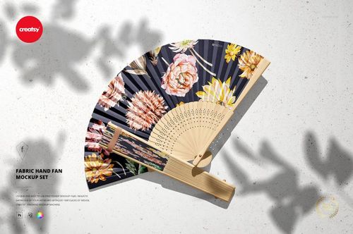 PSD mockup of a fabric hand fan with a wooden frame, decorated with vibrant floral designs on a dark background.