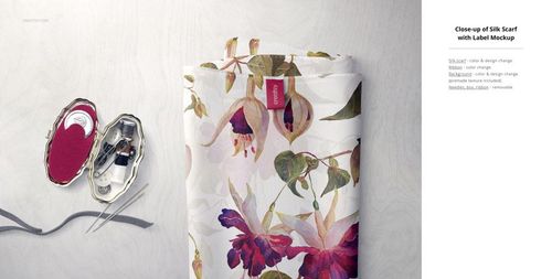 Folded silk scarf mockup featuring a botanical print, shown with needles and thread in a decorative case.