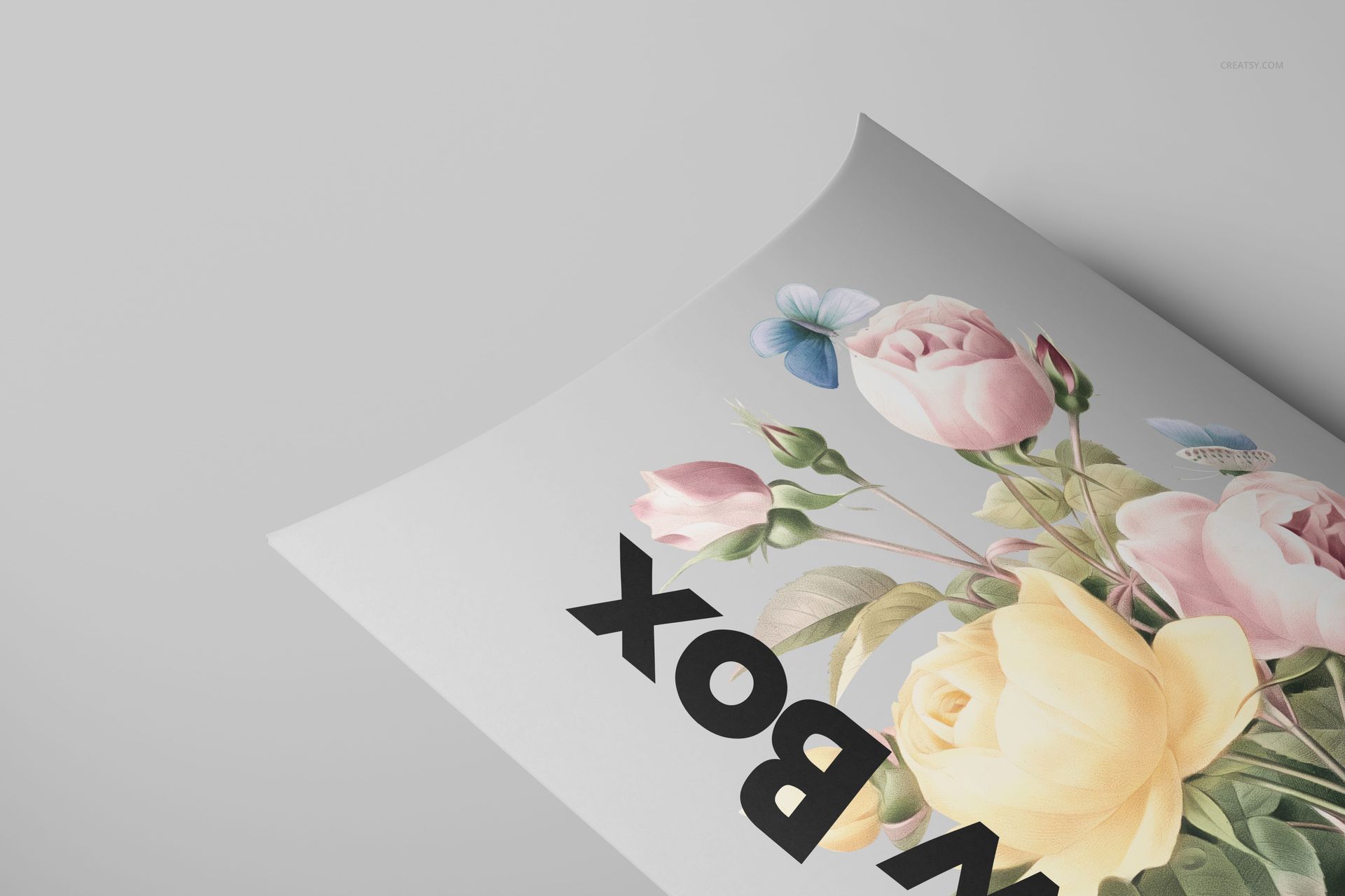 Matte pillow box mockup with floral illustration and bold black text, shown from a close-up angled view.