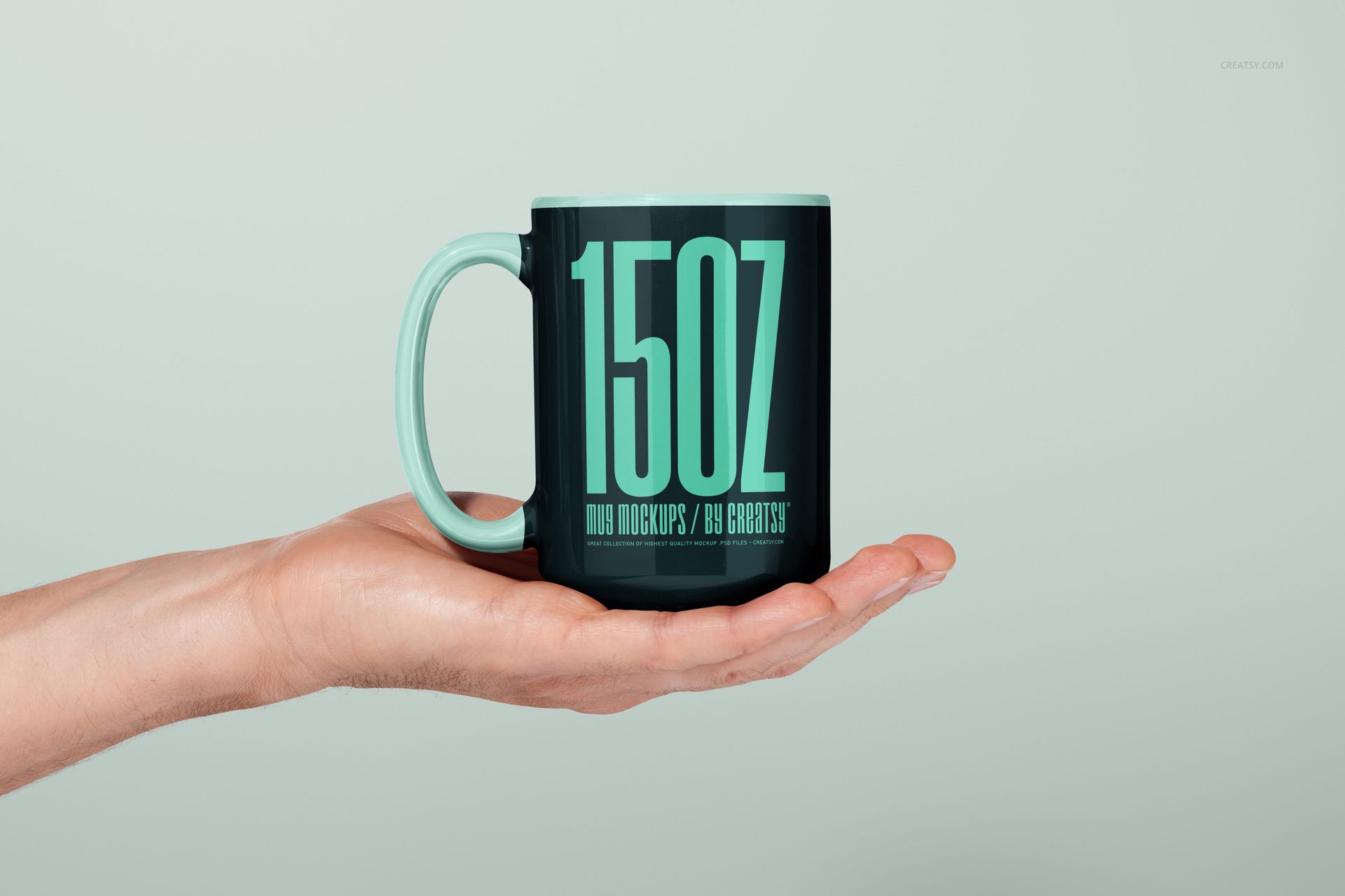 PSD mockup of a 15oz mug featuring a matte black surface, mint green accents, and bold typography, held in a hand.