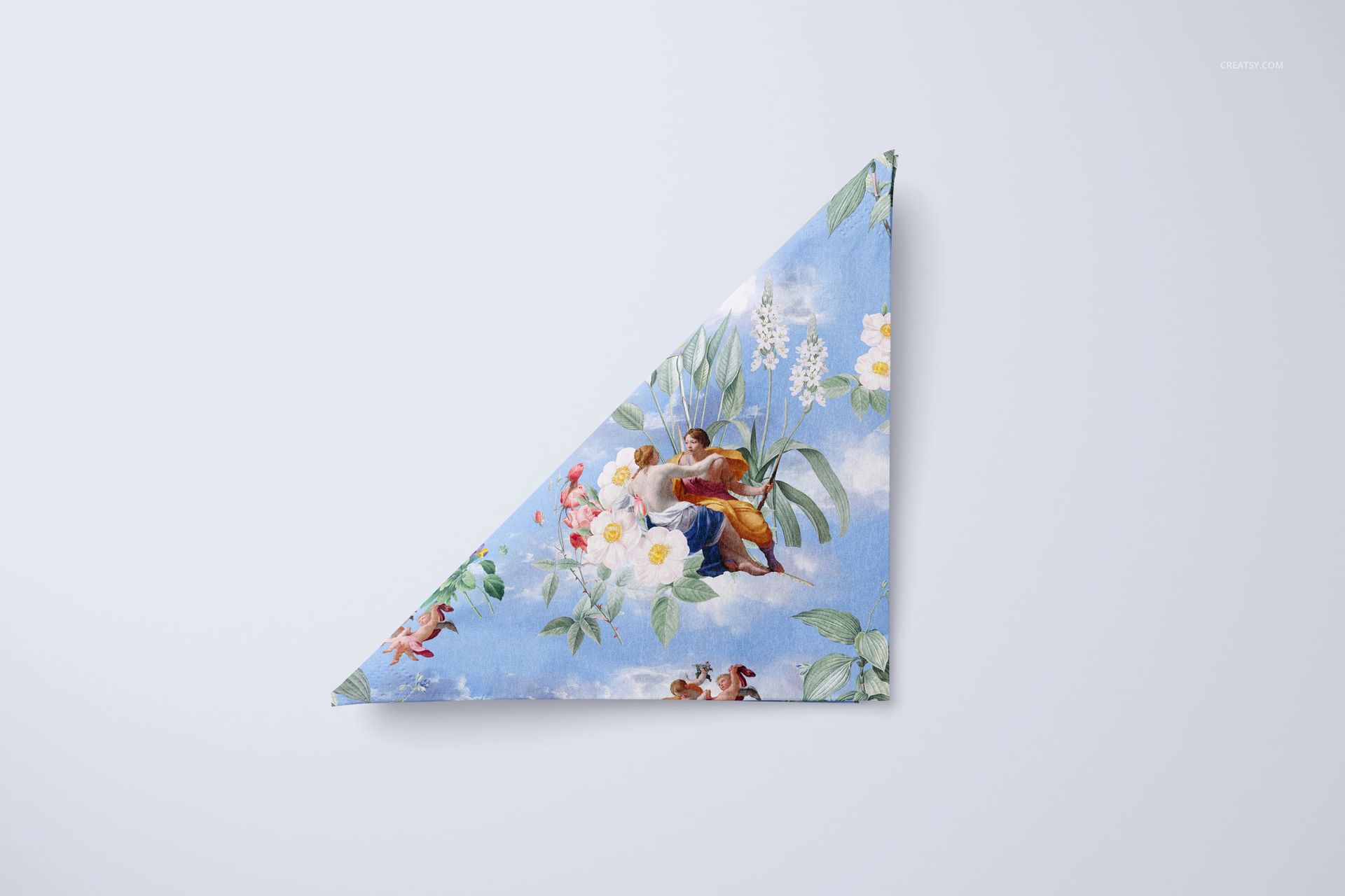Napkin mockup displaying a triangular fold, decorated with flowers and artistic figures on a light blue surface.