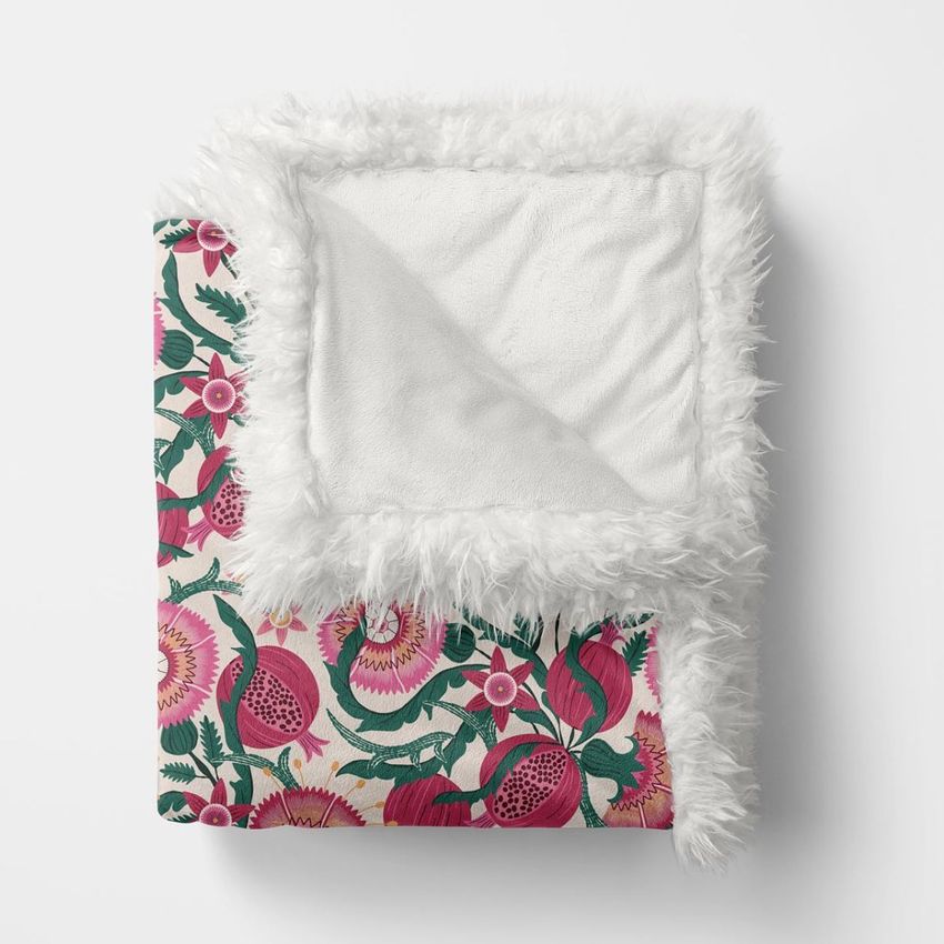 Sherpa baby blanket mockup featuring a folded blanket with a vibrant floral pattern in pink and green, white fluffy trim, and a soft inner lining on a plain white background.