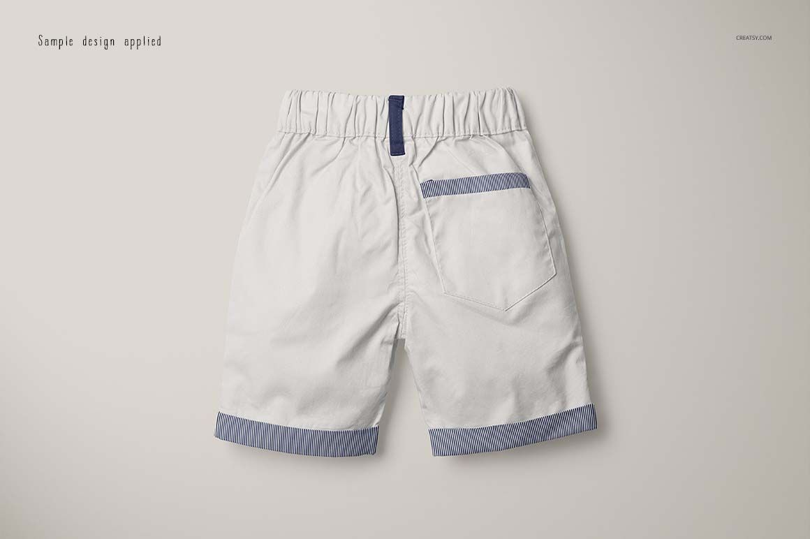 Back view of boys formal shorts mockup in white with blue striped trim on the pocket and leg cuffs on a plain background.