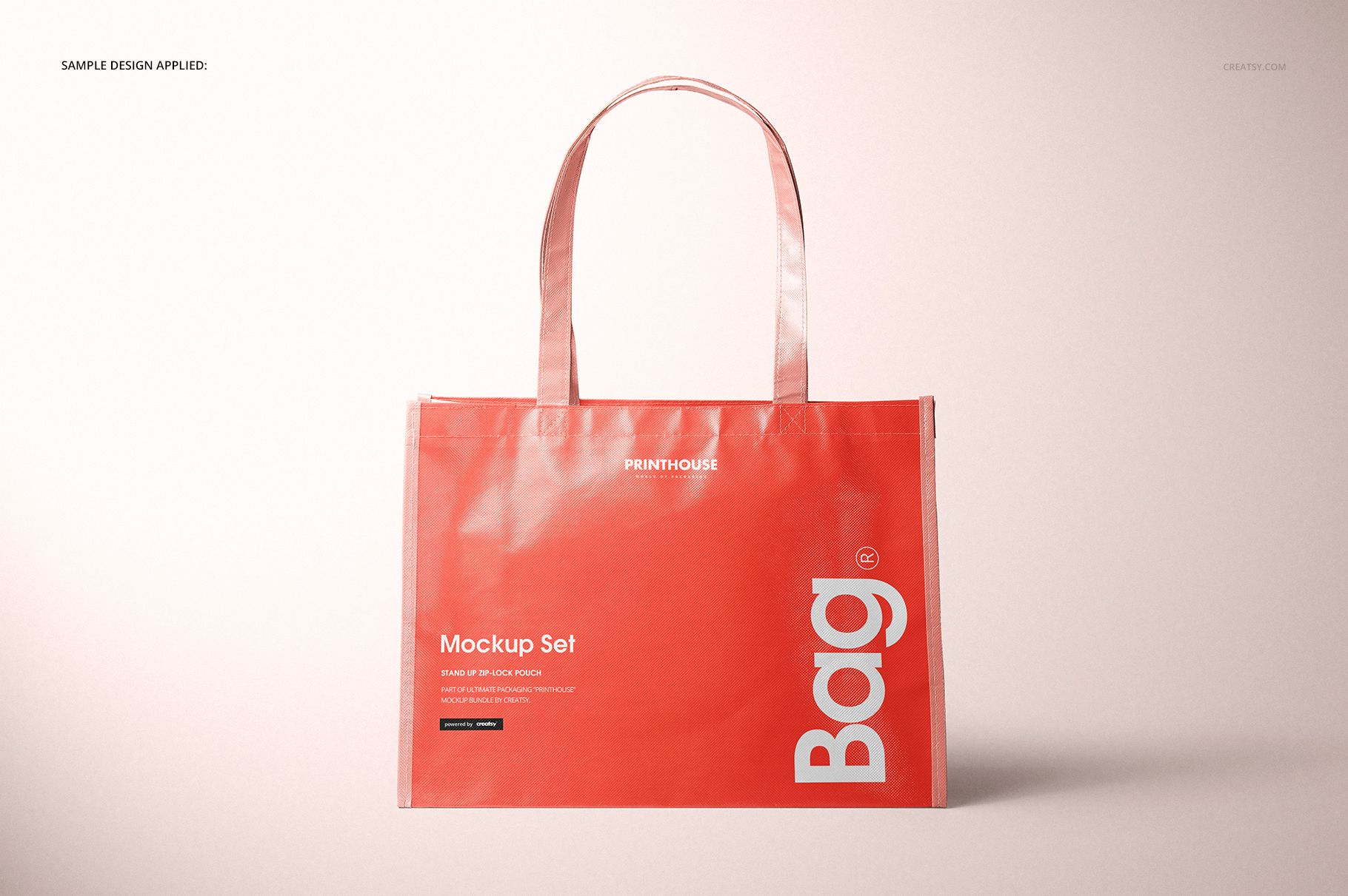 Laminated non-woven tote bag mockup shown upright against a neutral background, coral color with bold white typography.