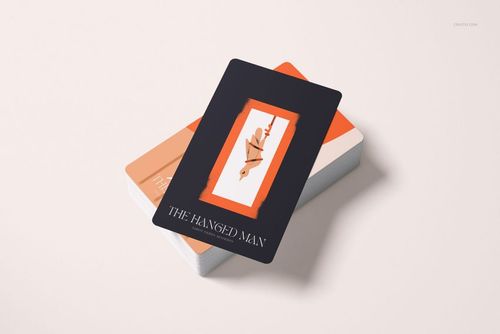 Front view of tarot card mockup set showing The Hanged Man card above a pile of cards with muted colors.