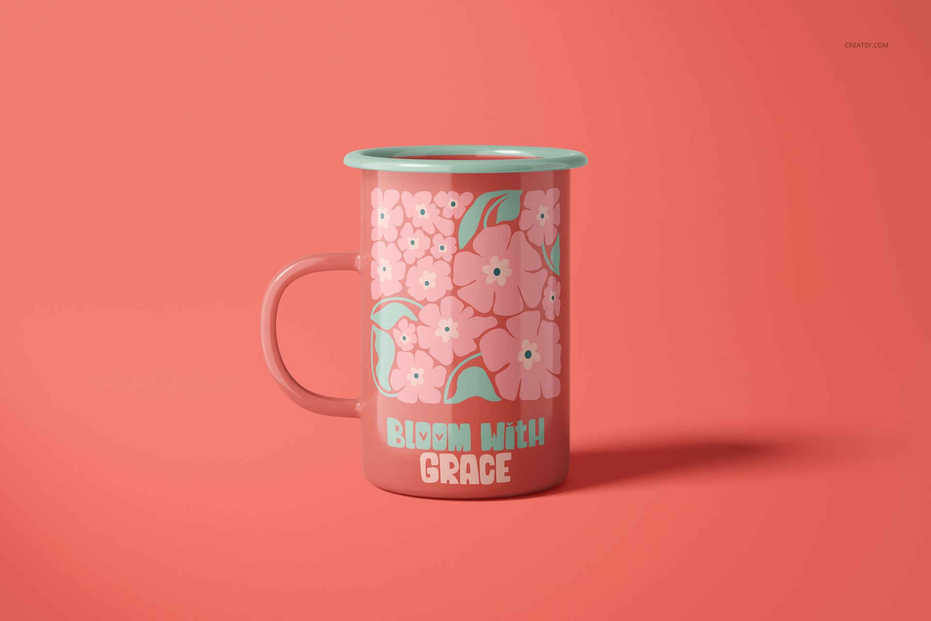 450ml enamel mug mockup featuring pink flowers and mint green accents, displayed upright on a solid coral surface.