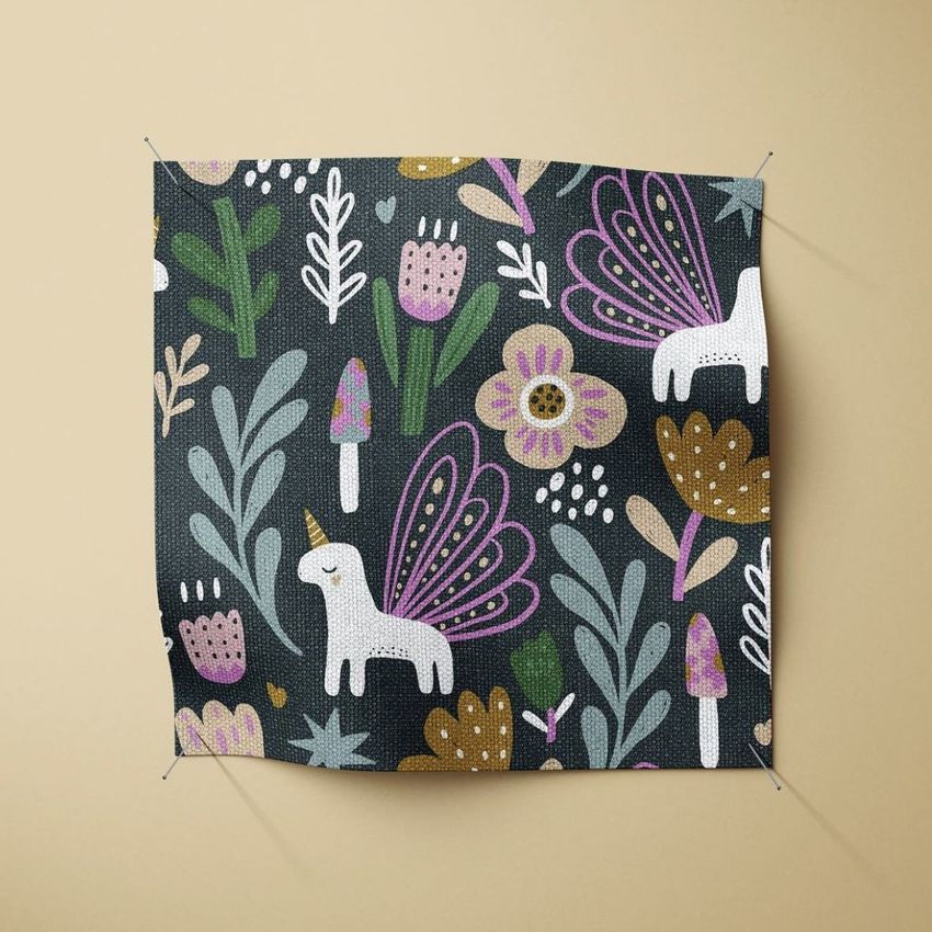 Fabric swatch mockup featuring a whimsical pattern with white unicorns, pink and gold flowers, and green leaves on a dark background.