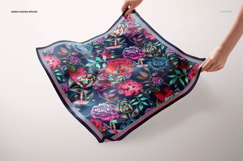Colorful square silk scarf mockup featuring bold flower designs, shown from a top view with hands holding the corners.