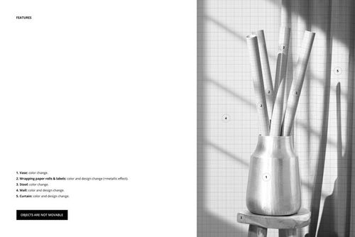 PSD mockup showing wrapping paper rolls in a vase, with a grid-patterned wall and strong natural light from the side.