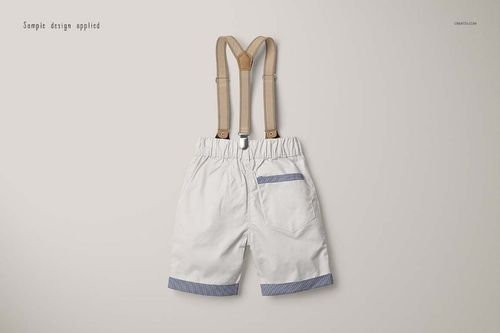 White boys shorts with blue striped accents and tan suspenders, displayed in a flat lay mockup on a neutral surface.