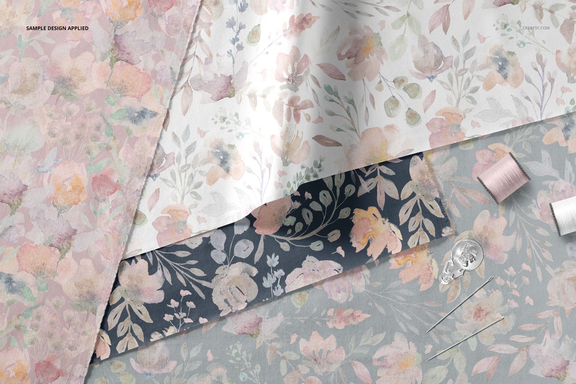 Layered fabric mockup showing three textile pieces with floral patterns in pastel and dark tones, top view.
