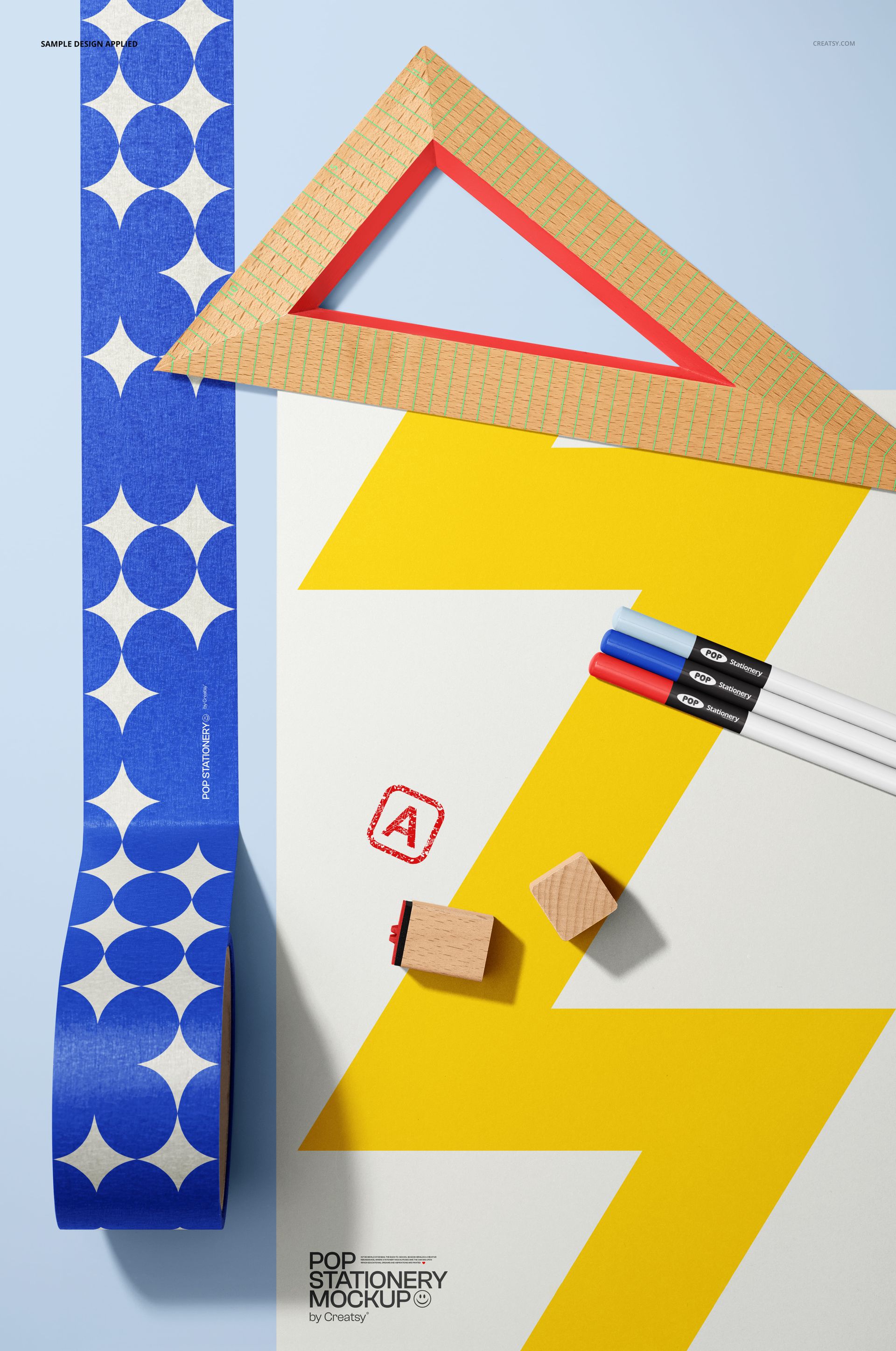 Front view of a stationery mockup featuring a poster with a bold yellow zigzag, blue patterned masking tape, pens, and geometric props.