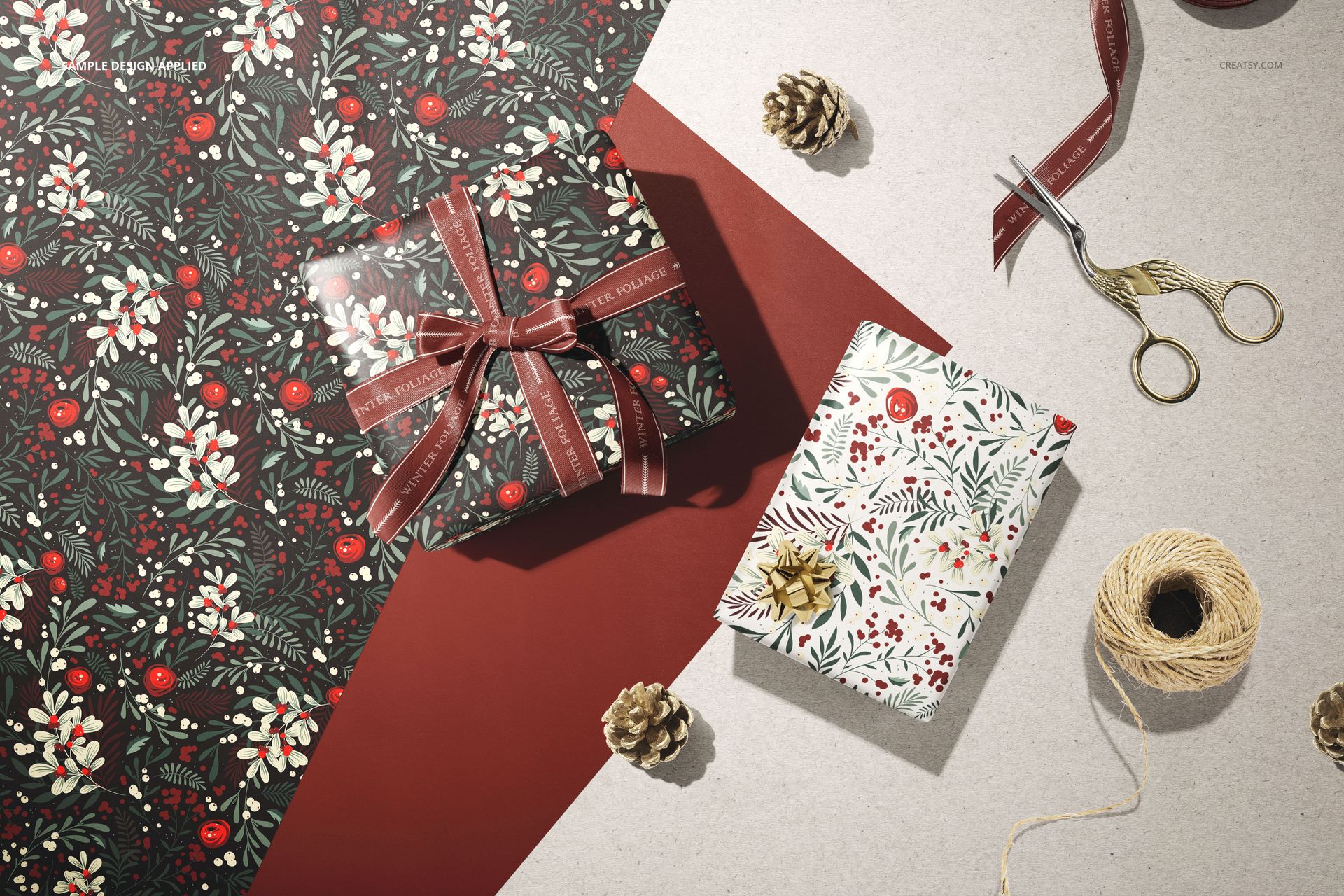 Wrapping paper mockup featuring two gift boxes with floral and berry patterns, seen from a top view with props.