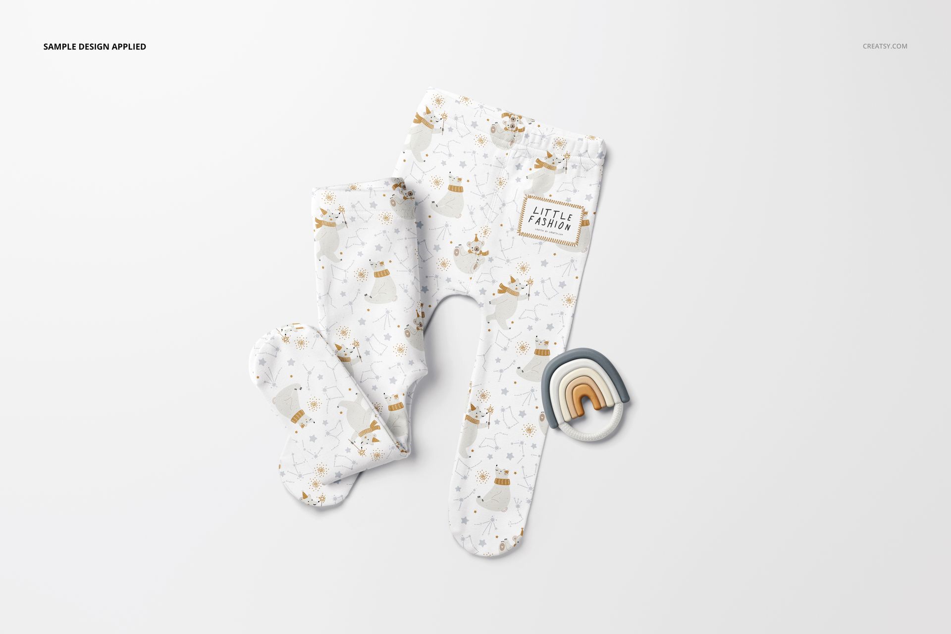 Mockup of footed baby leggings featuring playful bear and star patterns in soft colors, shown with a rainbow prop.