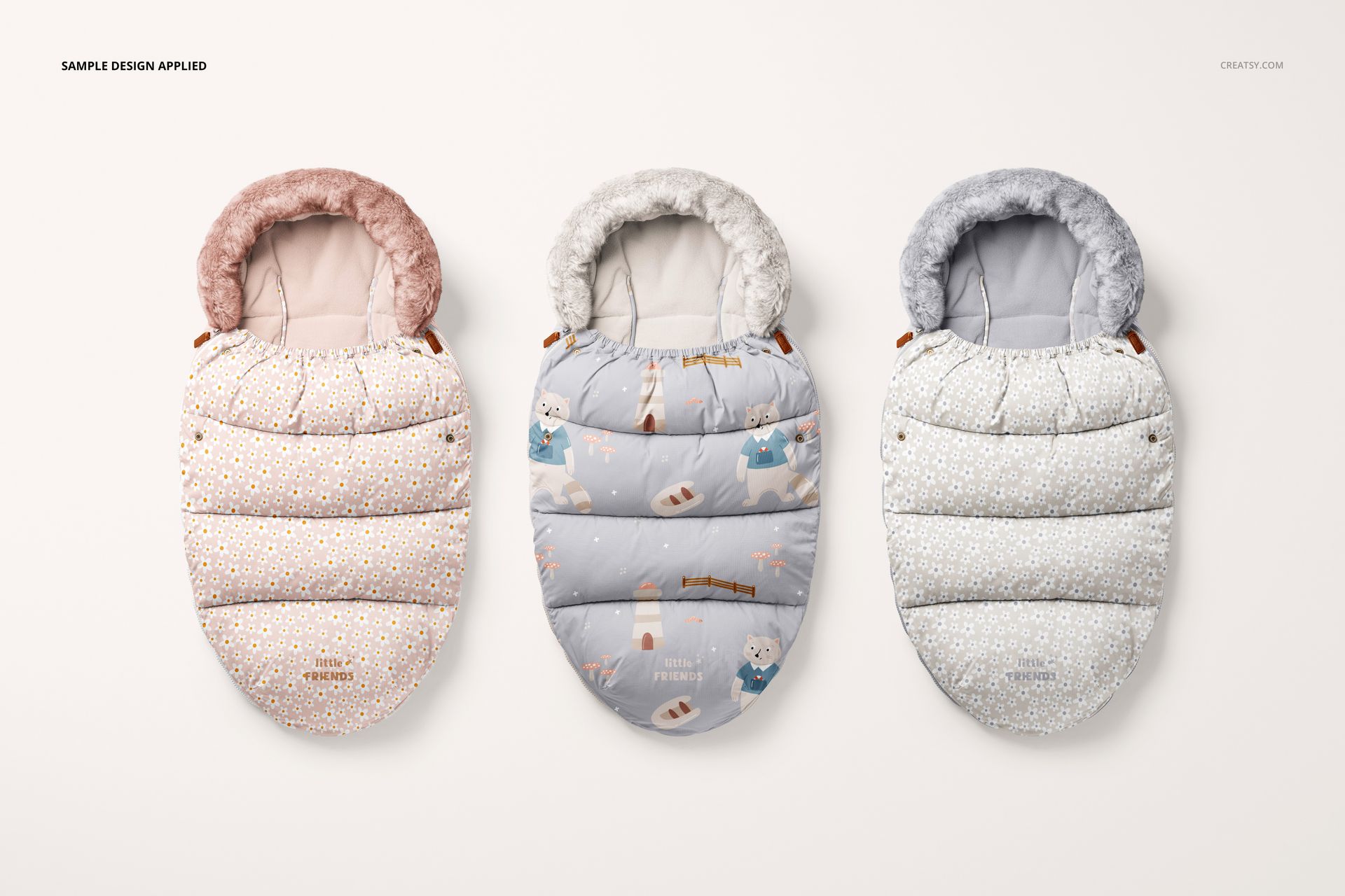 PSD mockup showing three children’s footmuffs with different designs and textures, arranged in a row on a plain surface.