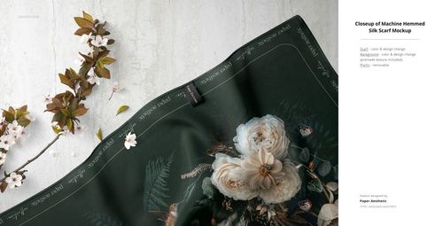 Silk fabric mockup with dark green background, white floral print, and machine hemmed edge, shown from above.