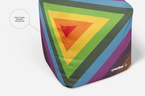Close-up of a cube ottoman mockup displaying bold, colorful triangular stripes and a small Creatsy logo in the corner.