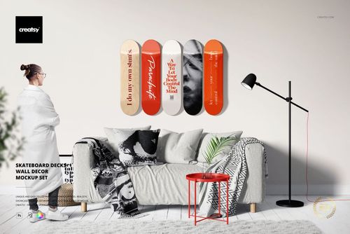 PSD mockup showing skateboard decks with varied patterns arranged above a couch, with a person standing nearby.