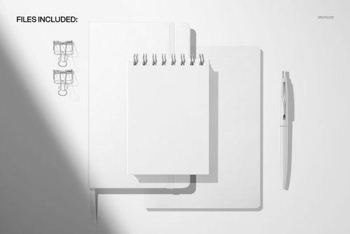 Top view of a spiral notepad mockup set with a leather planner, notebook, pen, and binder clips on a white background.