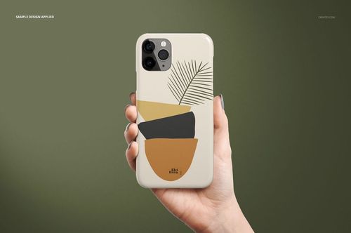 iPhone 11 Pro glossy case mockup showing abstract yellow, black, and brown shapes with a leaf, held in a hand.