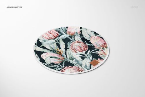 Knitted round rug mockup featuring large pink flowers and green leaves, shown from above on a plain surface.