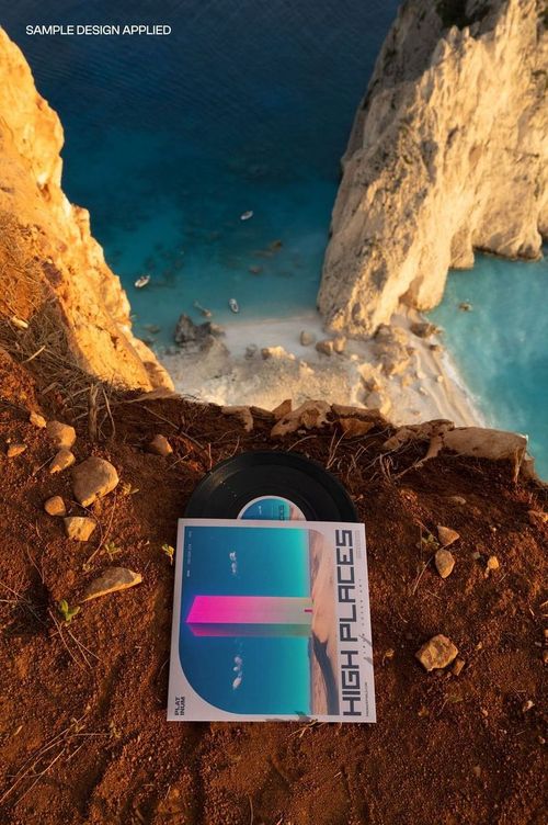 Top view of a 7 inch vinyl record and cover mockup set on reddish cliff soil above a blue coastal scene.