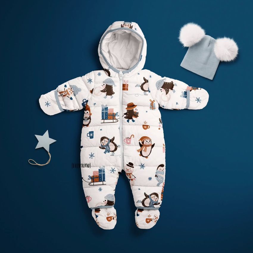 Baby snowsuit mockup displayed on a blue background, featuring a penguin pattern, with a gray hat and star-shaped prop nearby.