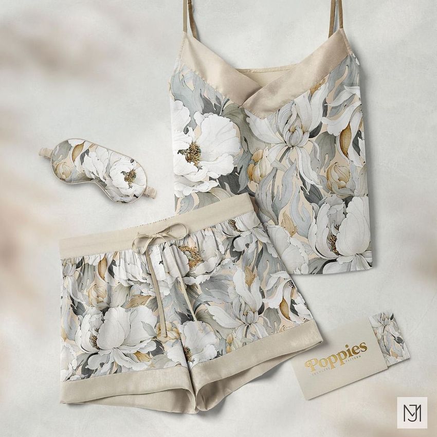 Short silk pajama mockup set featuring a camisole, shorts, and sleep mask with a soft floral poppy pattern on a light background.