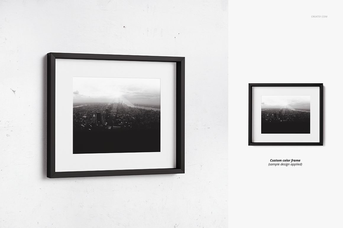 Picture frame mockup with black edges and white matte, featuring a monochrome city photograph, hung on a white wall.