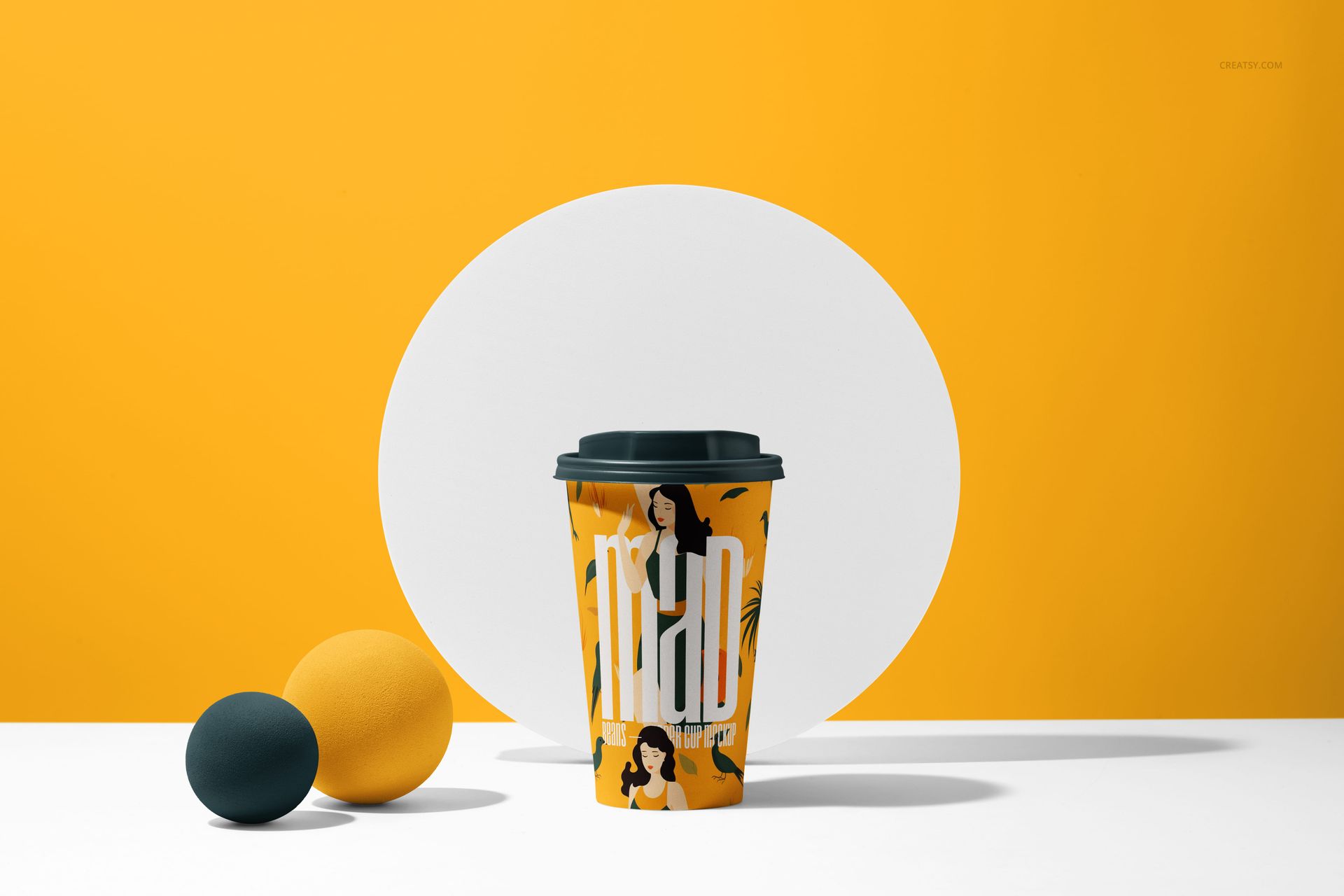 PSD mockup of a paper cup with a black lid, decorated with bold yellow graphics, placed before a white circle backdrop.