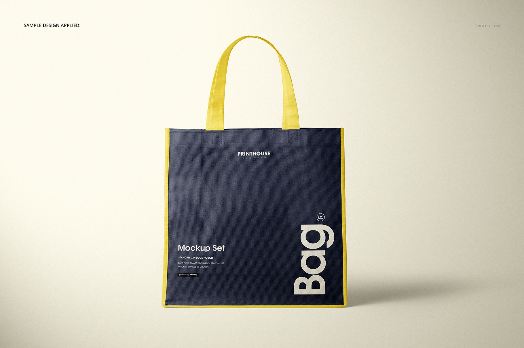 Front view of a non-woven tote bag mockup with navy blue body, yellow handles and trim, displayed on a neutral background.