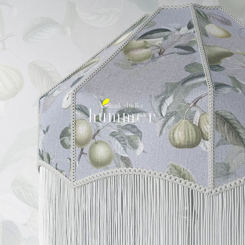 Tassel shade table lamp mockup featuring a close-up of a fabric lampshade with a botanical fruit pattern and long white fringe.