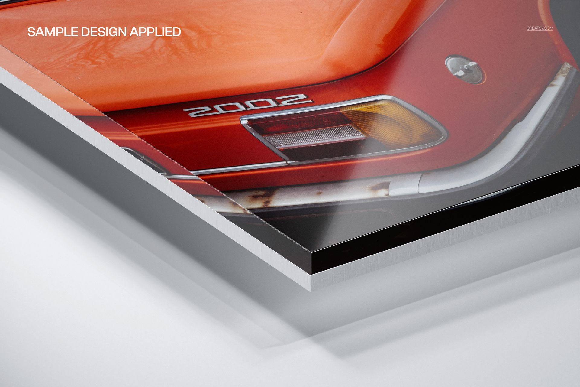 Acrylic photo print mockup showing a close-up corner view of a layered acrylic panel with a vintage car design.
