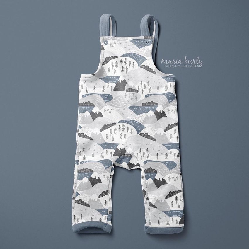 Kids fleece dungarees mockup displayed on a flat gray surface, featuring a mountain and valley pattern in blue and white tones.