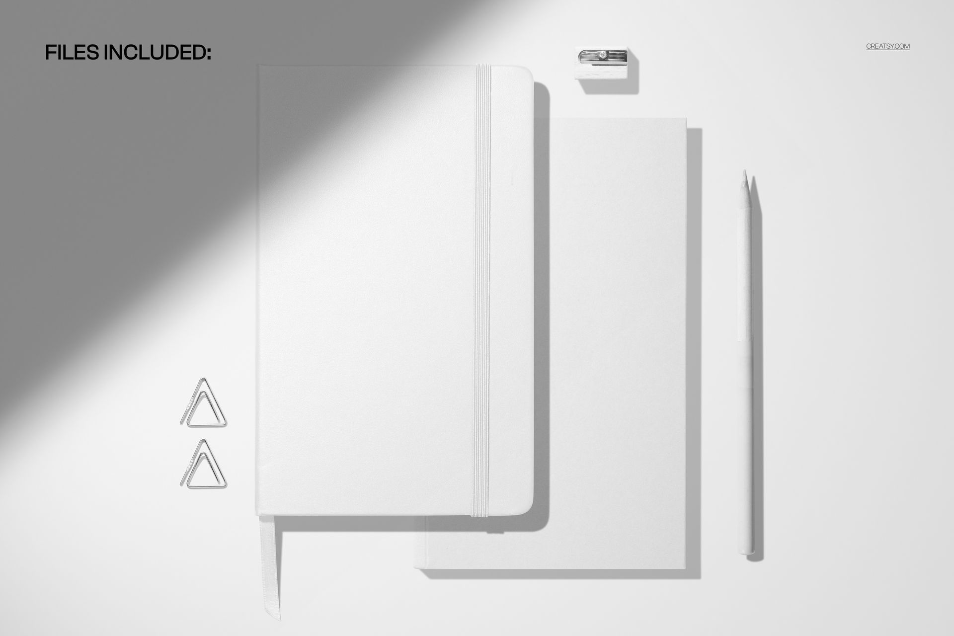 PSD mockup showing a planner, notebooks, pencil, and desk accessories under a strong spotlight shadow effect.