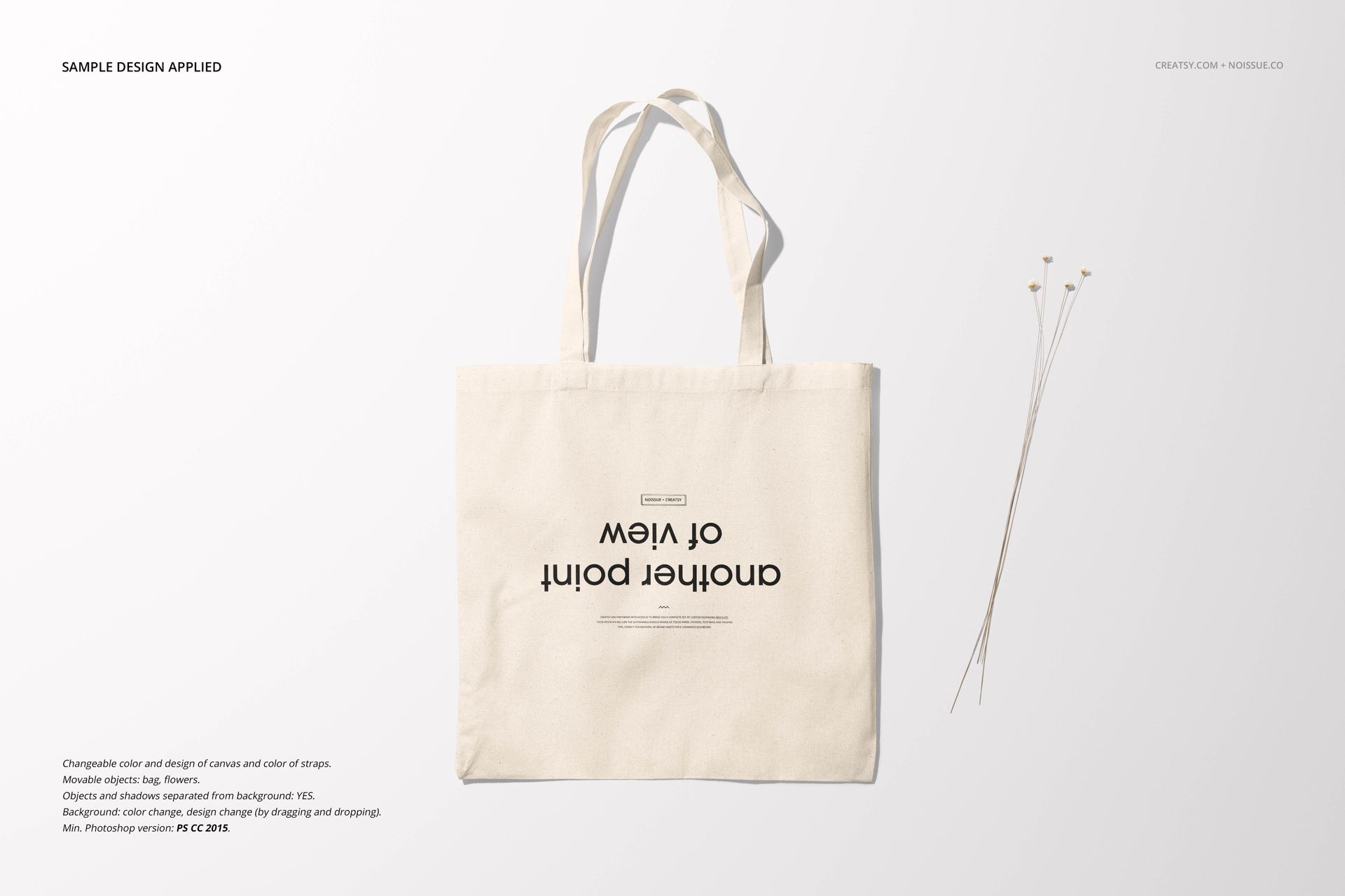 Front view of a plain canvas tote bag mockup with long handles, displayed on a light background with minimal props.