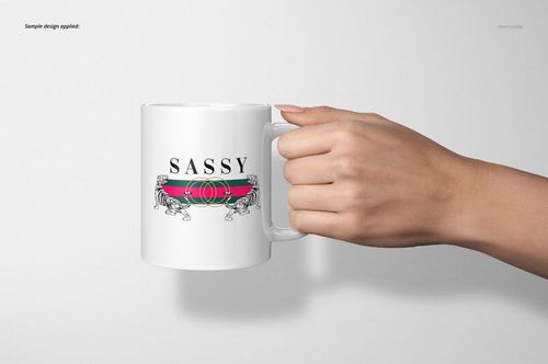 White 11oz mug mockup held by a hand, featuring a bold design with stripes and the word 'SASSY' on the front.