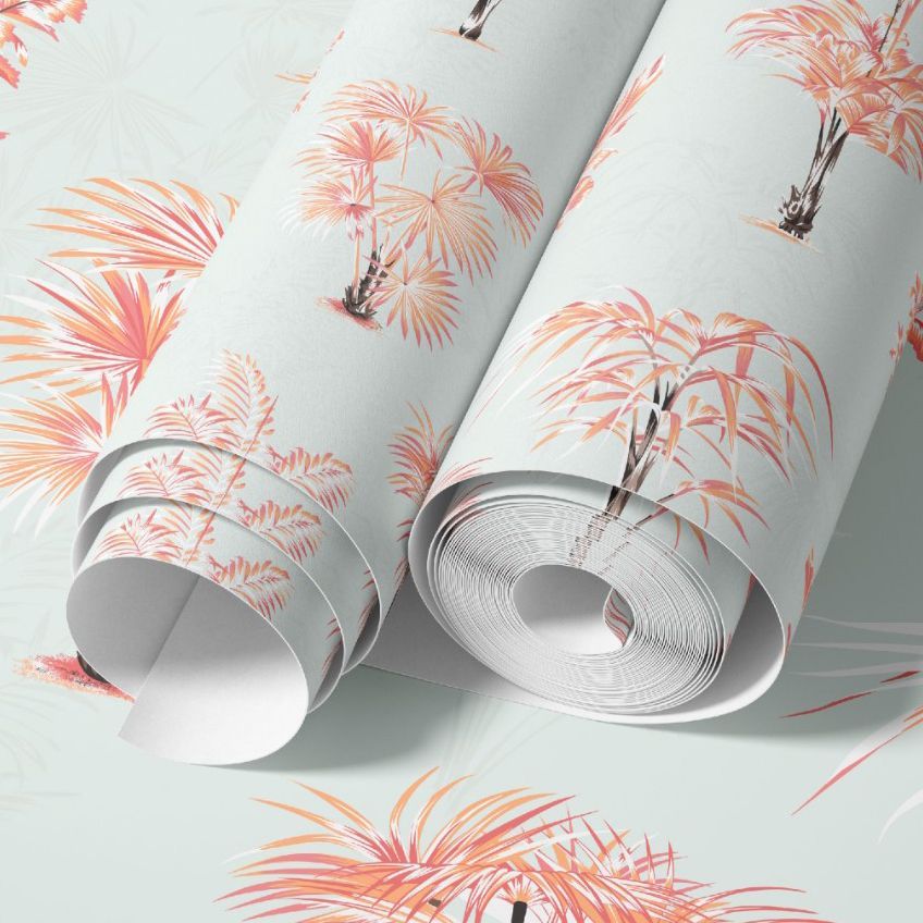 Paper wallpaper mockup featuring two rolled sheets with pink and orange palm tree prints on a light pastel background.
